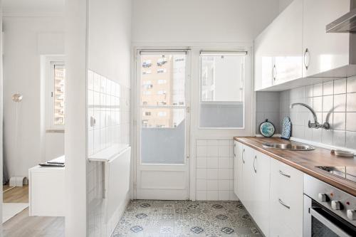 a white kitchen with a sink and a window at ALTIDO Striking flat in Benfica in Lisbon