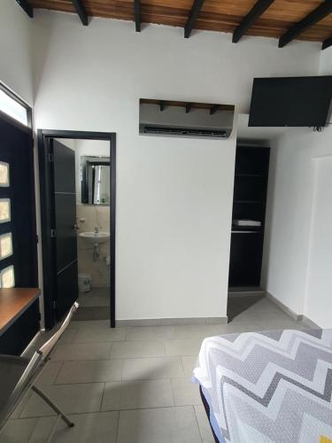 Ein weißes Zimmer mit einem Bett und einem Bad. in der Unterkunft Aptoestudio full equipado y excelente ubicación in Cúcuta