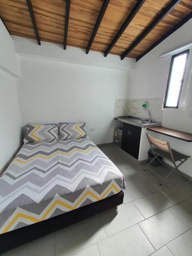 Schlafzimmer mit einem Bett, einem Schreibtisch und einem Stuhl in der Unterkunft Aptoestudio full equipado y excelente ubicación in Cúcuta