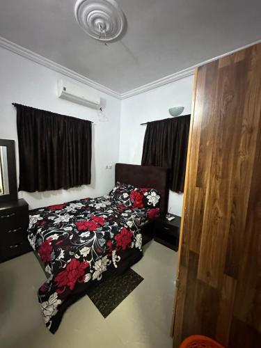 a bedroom with a bed with a floral comforter at Cozy one bedroom, Lekki-ikate in Lagos