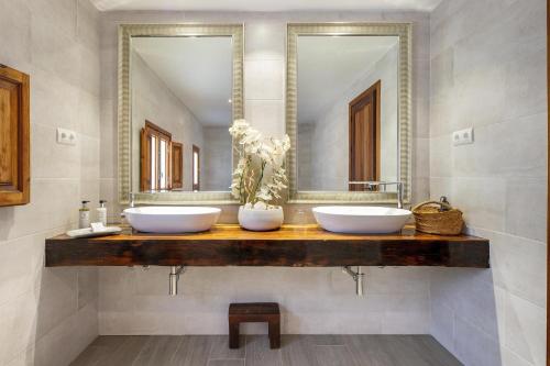 a bathroom with two sinks and a large mirror at Can Torres in Santa Eularia des Riu