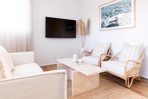 a living room with two chairs and a table and a tv at Rosebay - Coastal Holiday Home in Rosebud