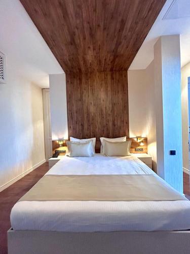 a bedroom with a large bed with a wooden ceiling at King Sky Tower Hotel in Batumi