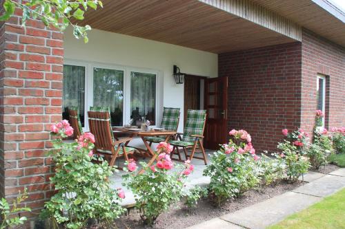 un patio con mesa, sillas y flores en Ferienhaus Dorit & Rüdiger Fahl, en Klocksdorf