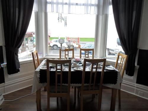 a dining room table and chairs in front of a window at The waterfront hotel in Blackpool