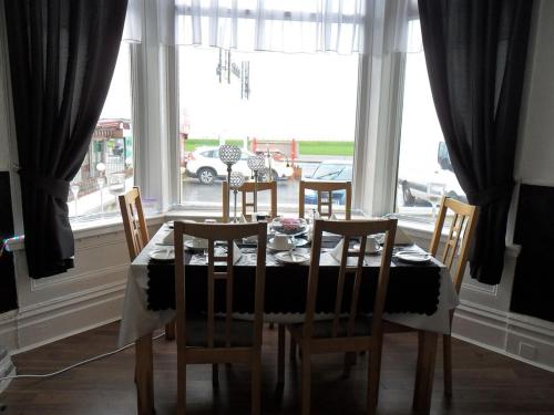 a dining room table and chairs in front of a window at Anzy Panzy Hotel and Apartments in Blackpool