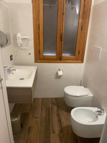 a white bathroom with a toilet and a sink at VILLA MARGHERITA in Pieve di Soligo