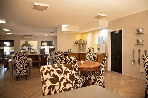 Una sala de estar con sillas y una mesa y una cocina. en Stay, en Postmasburg