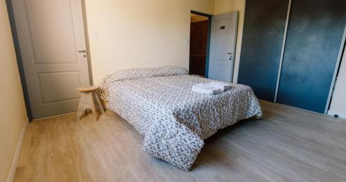 La Casita Boutique في تشوس مالال: غرفة نوم صغيرة مع سرير وطاولة