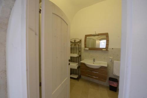 een badkamer met een wastafel en een spiegel bij DOMUS PRAETORIA in Alberobello