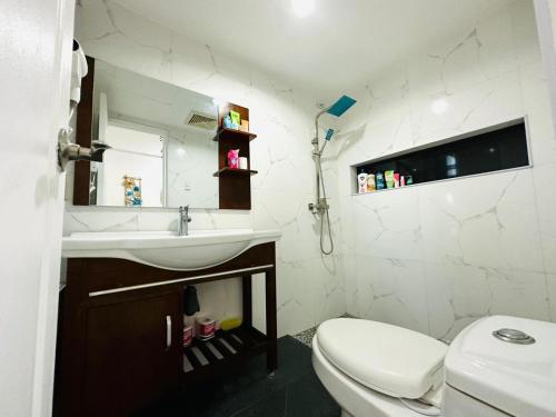 y baño con lavabo y aseo. en Group-Friendly Cebu Condo with Mall Access, en Cebú