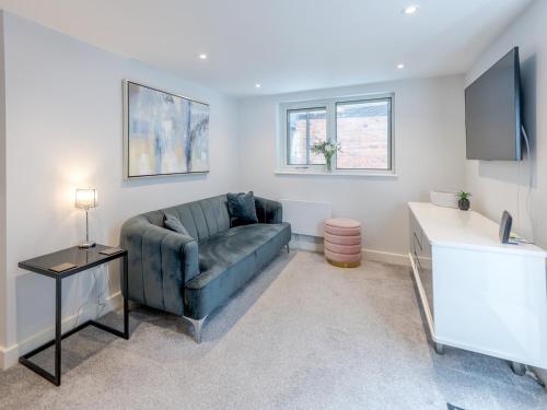 a living room with a couch and a television at Bouvardia Modern town centre apartment - Pass the Keys in Shrewsbury