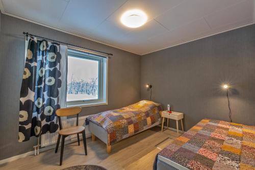 sypialnia z 2 łóżkami i oknem w obiekcie Ahma Mökki w mieście Kilpisjärvi
