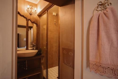 a bathroom with a sink and a shower with a towel at Hotel Oviv dimora del borgo in Acquaviva Picena