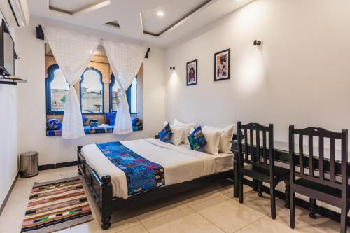 ein Schlafzimmer mit einem Bett und zwei Fenstern in der Unterkunft The Legend Haveli in Jaisalmer
