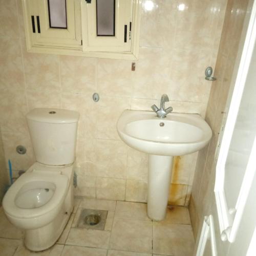 La salle de bains est pourvue d'un lavabo et de toilettes. dans l'établissement الاسكندريه خالد بن الوليد, à Alexandrie