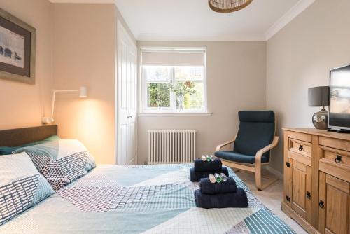 1 dormitorio con 1 cama, 1 silla y TV en Modern Two Bedroom Apartment, Roseburn, Edinburgh - Free Parking en Edimburgo