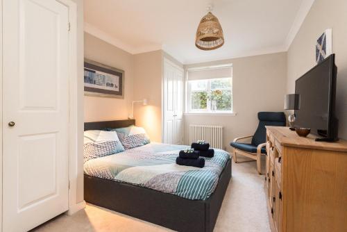 a small bedroom with a bed and a television at Cosy Roseburn Apartment, Edinburgh - 2 Bedrooms, FREE PARKING in Edinburgh
