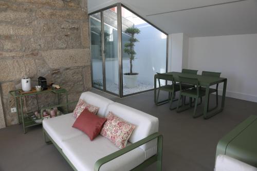 a living room with a white couch and a table at Avenida Viana Boutique Suites in Viana do Castelo