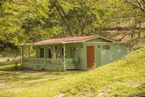a small green house with a red roof at Villas La Paillote Costa Rica in Puntarenas