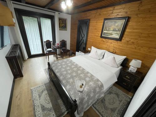 a bedroom with a large bed and a wooden wall at Pensiunea Eugenia in Bran