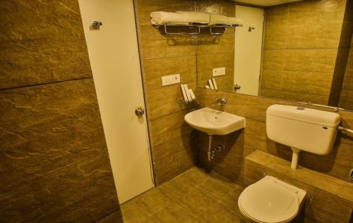 a bathroom with a toilet and a sink at Studio Flat Near Airport in Surat