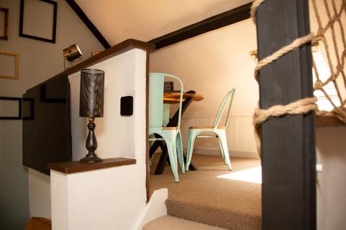 a room with a staircase and a table and chairs at Quirky Boutique 1840s Stable in Torquay