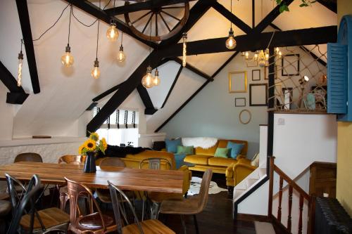 a living room with a wooden table and chairs at Quirky Boutique 1840s Stable in Torquay