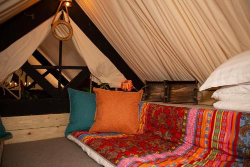 a couch with colorful pillows in a tent at Quirky Boutique 1840s Stable in Torquay