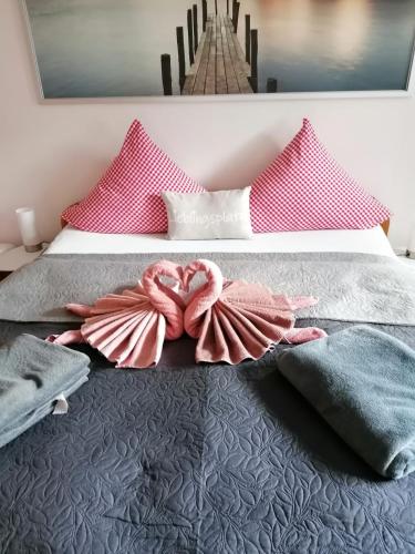 a bedroom with a bed with pink pillows at Ferienhaus Gertrud in Nesselwängle