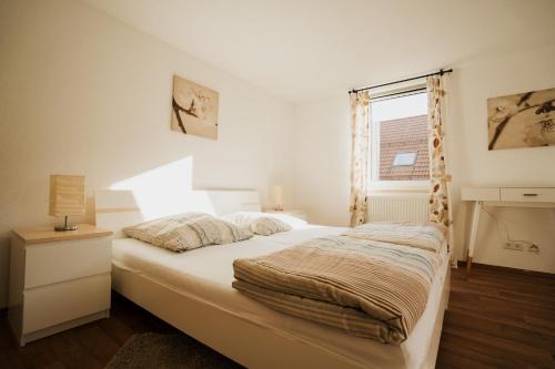 a bedroom with a white bed with a window at MaTi´s Appartment 