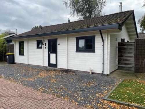 a small white house with a porch at De Genten 2, Vakantiewoning met jacuzzi en sauna in Ermelo
