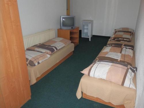 a room with two beds and a television in it at Ubytovna u hospůdky in Ostrava