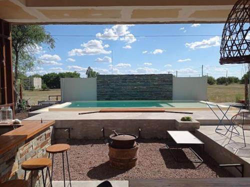 Un patio trasero con piscina, mesa y sillas. en Tranquilidad plena y Termas., en Villa Elisa