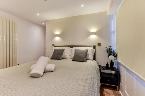 a bedroom with a large white bed with two pillows at Spacious Brighton Home 2 Ensuites, Weekly & Monthly Stays-Marine LGF by Bluehouse Shortlets Brighton in Brighton & Hove