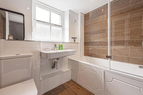 a white bathroom with a sink and a shower at Character Townhouse in Town Centre & Superb Views in Dolgellau