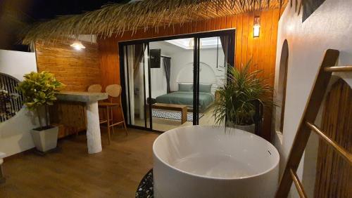 a room with a bathroom with a tub and a bedroom at บ้านมัจฉา in Ko Larn