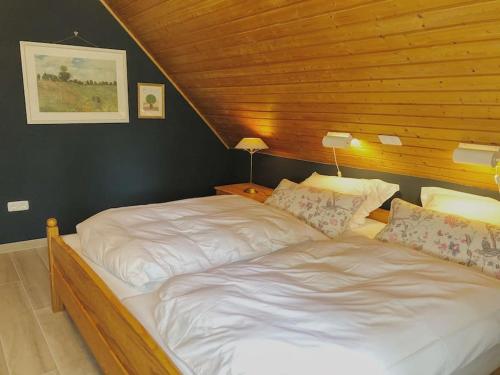 2 bedden in een slaapkamer met een houten plafond bij Gästehaus im Garten in Zeitlofs