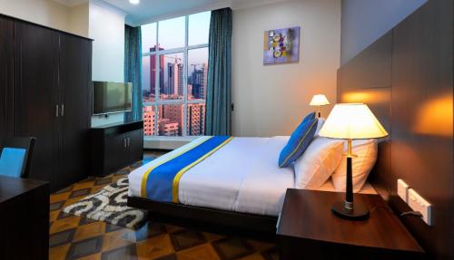 a hotel room with a bed and a television at Amber Tower in Al Ghurayfah