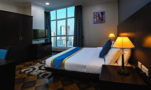 ein Hotelzimmer mit einem Bett und einem großen Fenster in der Unterkunft Amber Tower in Al Ghurayfah