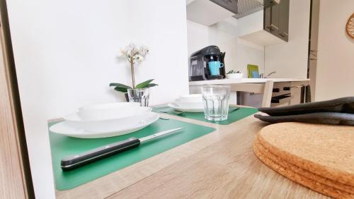 une table avec des assiettes et des verres au-dessus dans l'établissement Le Ptit Paradis - Calme - Wifi - Cour privée - Relax BNB, à Mulhouse