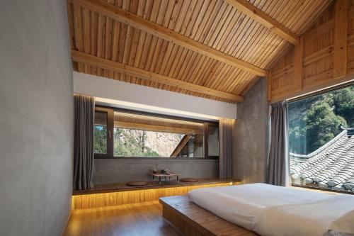 a bedroom with a large bed and a window at 雾里观阵山 Foggy Valley in Zhangjiajie