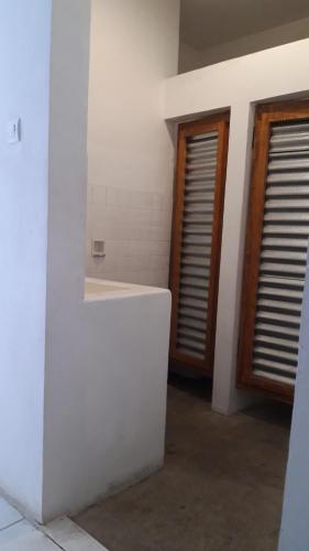 a bathroom with a white sink and two windows at Wayang BnB in Yogyakarta