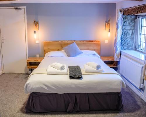 ein Schlafzimmer mit einem großen Bett mit Handtüchern darauf in der Unterkunft Mullions 51 B&B in Street