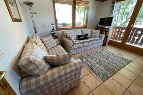a living room with two couches and a television at Les Granges 13 6-8 person in Aime-La Plagne