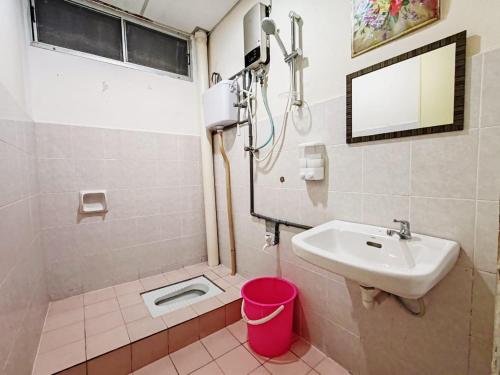 a bathroom with a sink and a shower and a mirror at Fausal Legacy Homestay Sungai Besar in Sungai Besar