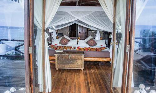 a bedroom with a bed with a canopy at Zi Villa Main House in Matemwe