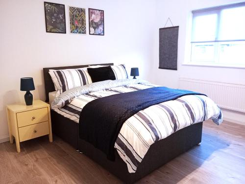 a bedroom with a bed and a night stand at Stourbridge - Dudley - Luxurious 5 Beds - DY2 - Long Stay for Contractors & Families in Woodside