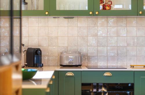 a kitchen with green cabinets and a toaster on the counter at Lisie Sprawki in Bebło