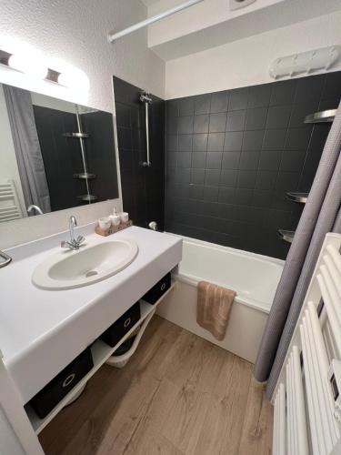 une salle de bain avec un lavabo et une baignoire dans l'établissement Le Solaret 1 4-6 person, à Aime La Plagne